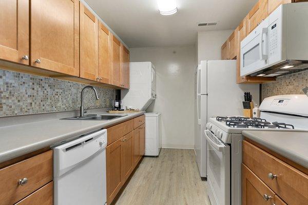 This is our contemporary kitchen style, complete with soft-close cabinetry, glass tile backsplash, and luxury plank flooring.