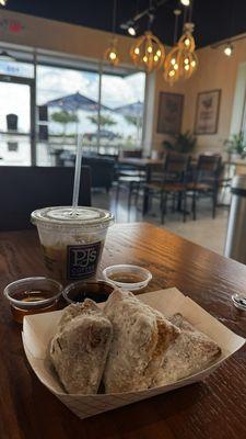 Small order of beignets with honey, chocolate, and caramel sauces and a small iced Southern Birthday Cake coffee.