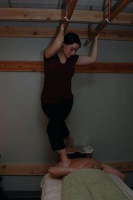 Amanda performing Ashiatsu Massage. With the use of barres overhead she is able to control pressure and weight distribution.