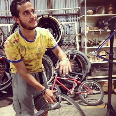 A volunteer mechanic helps fix a bike at Bici.