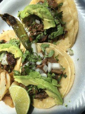 Tres tacos al pastor con avocado.