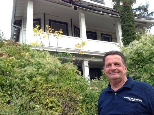 American Roofing's Ed Purcell in front of house with crumbling roof fall 2014.