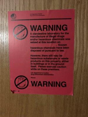 Sign on a room door about drug lab