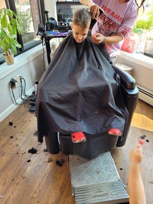 The owner cutting my oldest son's hair. Fixed the uneven line.