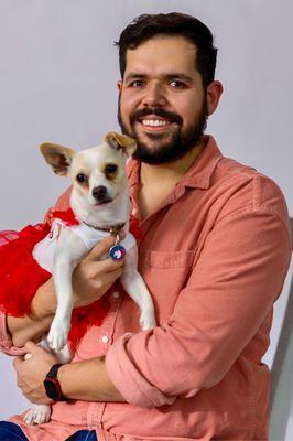 Male and little dog with red dress.