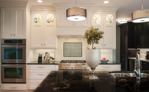 Lighted glass doors and a traditional white kitchen.