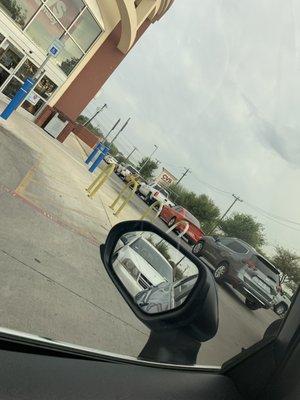 Line of cars wrapping around pharmacy waiting for RXs