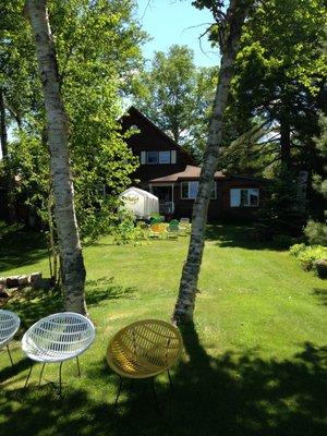 View looking back up to the owners house from the lake. Cool vintage lawn chairs!