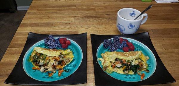 Breakfast  loaded omelet with turkey, tomato, veggies, and spinach; fruit on side