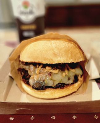 Smokehouse burger. It had cheddar cheese, carnitas, fried onions, pickles, butter, salt, pepper, and BBQ sauce.