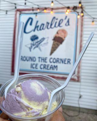 One big scoop of Honey lavender ice cream in a cup in front of their sign