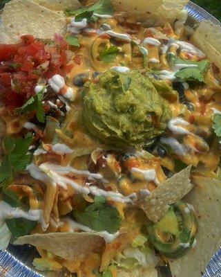 Fully Loaded Nachos! Tortilla chips, plant based ground beef, black beans, queso, sour cream, jalapeños, pico de gallo, and guacamole.