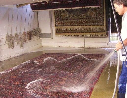 Gary Tulanian rinsing an Oriental rug