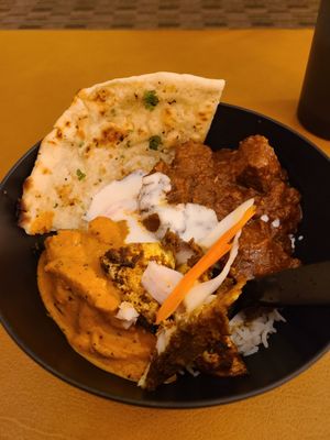 Butter chicken, garlic naan, goat tika masala, raita, and basmati rice