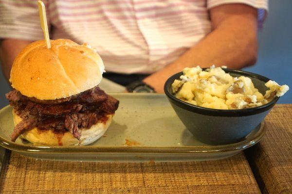 Brisket sandwich with side of mashed potatoes