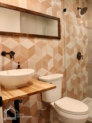 Bathroom remodel. decorative bathroom tile wall. Geometric shape tile. floating wood counter with vessel sink. wall mounted sink faucet. Bat