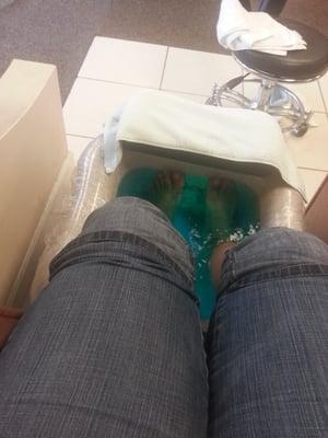 Soaking feet in the warm cozy water. Chair massage is taking care of the neck and back.