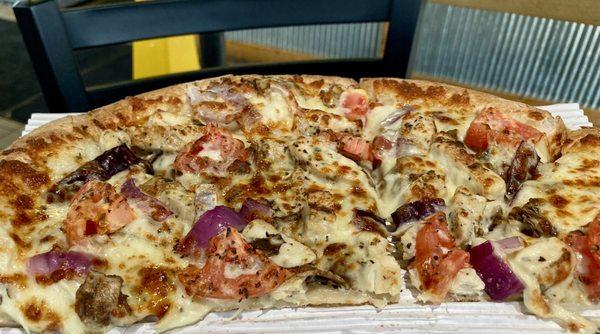 Chicken Alfredo pizza (Chicken, mushrooms, onions, tomatoes, Alfredo sauce and cheese).