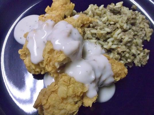 Crispy and buttery tenders topped with gravy and served with a side of dirty rice.