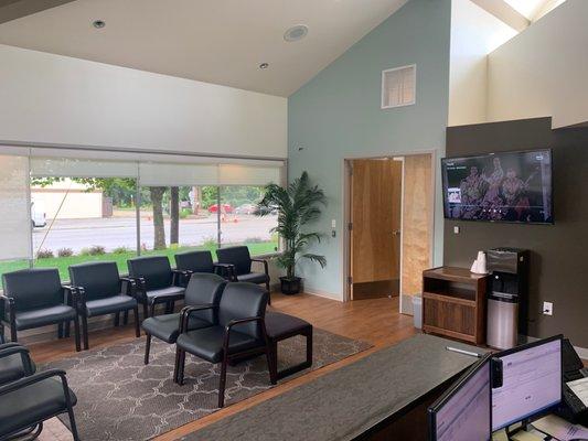 Comfortable and bright waiting room area with TV entertainment.