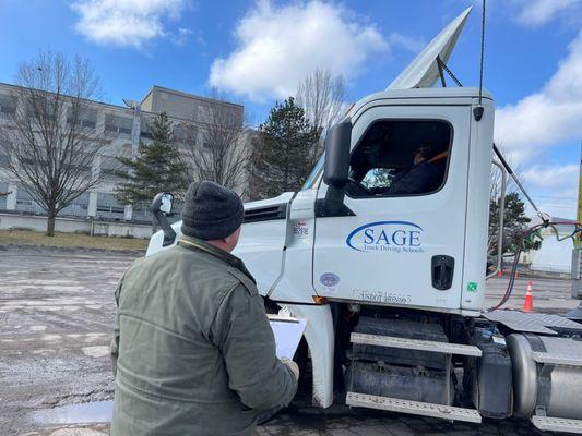 Sage Truck Driving School instructor teaching student in training truck.