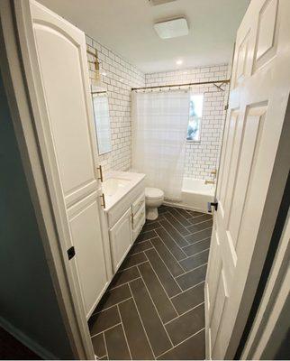 Guest bathroom upgrade with new flooring, tiled walls to ceiling, repainted cabinets, new hardware