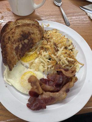 Eggs over easy, bacon, has browns, with rye bread