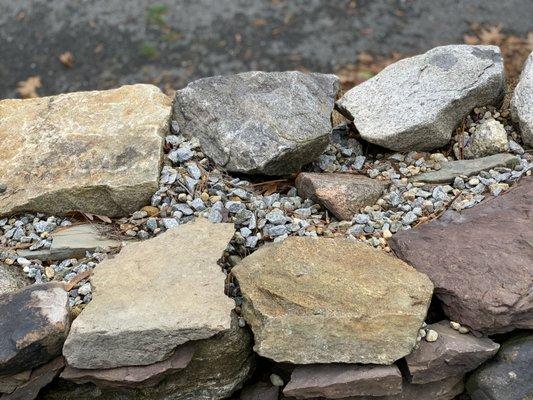 wall is filled with rock and small pebbles; stones aren't fitted