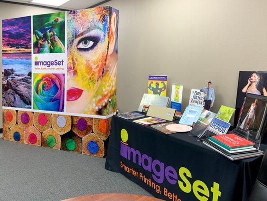 A diverse collection of printed items, including a large-format tradeshow display print, highlighting our versatile materials and styles.