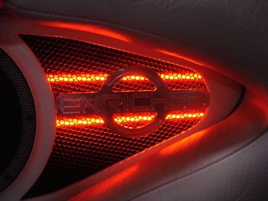 Custom machined Enriched logo in front of red lighting.