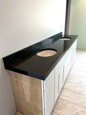 Beautiful double vanity from a quartz material featuring a laminated edge and matching backsplash!