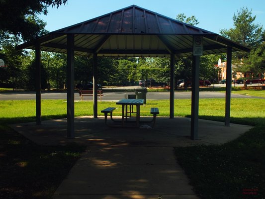 A covered pavilion with the basketball court in the background.