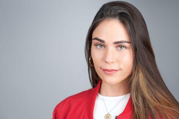 Business headshot of a woman with gray studio background.