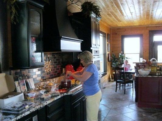 Granite counter tops in kitchen complement double oven, microwave oven, gas stove, commercial refrigerator and dishwasher.