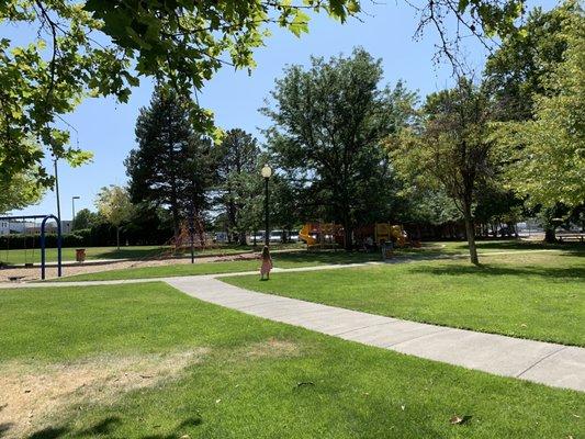 Large shady grass areas with picnic benches and paved pathways