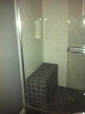 Tile shower with bench seat and shampoo niche.