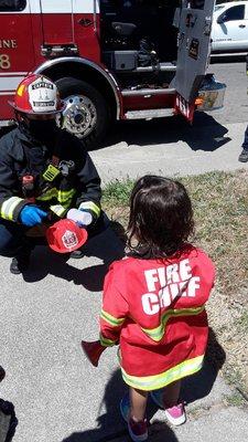 The fire fighters brought a official helmet and made her day wonderful.