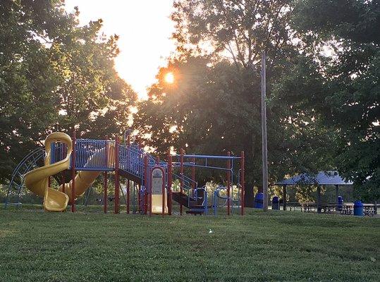 The modern playground with picnic pavilion behind.