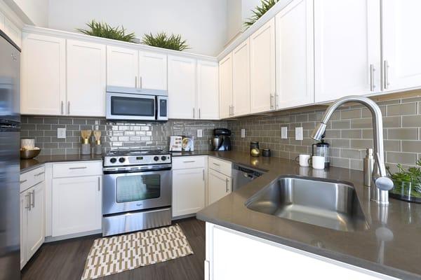 Hand-crafted, granite countertops with subway tiled backsplash, accompanied with state of the art stainless steel appliances.