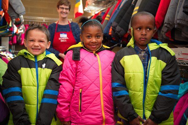 Kids getting fitted for new school clothes, Operation School Bell.