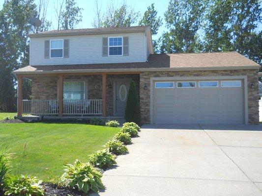 CUSTOM STONE, CEDAR POSTS, PVC RAILINGS, 8' INSULATED GARAGE DOOR