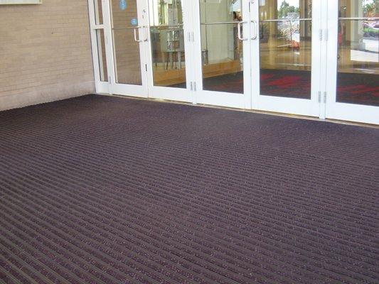 Vinyl roll goods solutions entrance matting for Vestibules: Ultra Entry™ shown here with carpet scraper inserts.