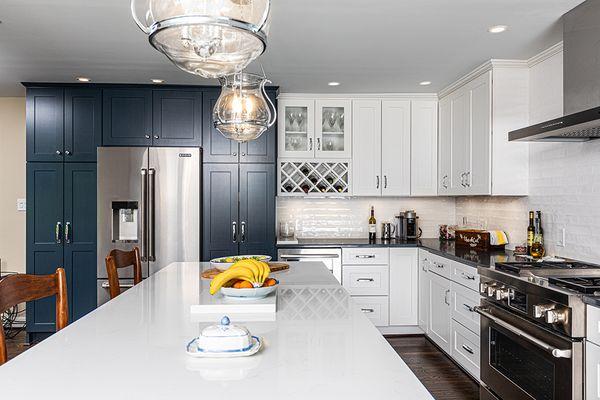 Utilizing wine racks and glass cabinetry offers a defined beverage station in this kitchen