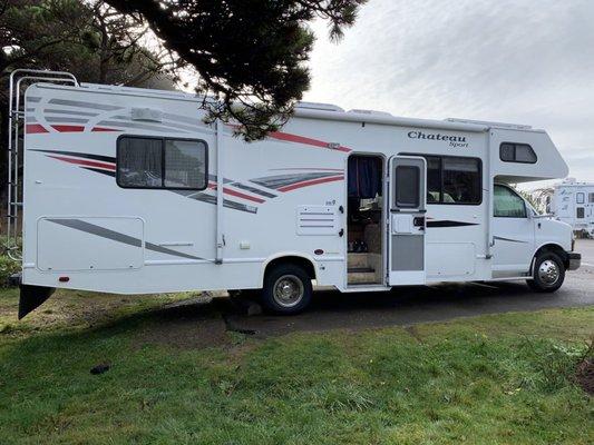 Customers photo of them camping in a parking lot without hookups and using the solars panels on the roof to keep the batteries charged.