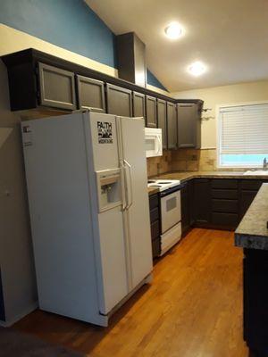 Old dark cabinet before repainted with old laminated flooring.