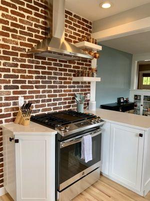 Our finished kitchen after Helton Enterprises added thin brick, installed countertops, a peninsula and hand-built cabinets, and a vent hood.