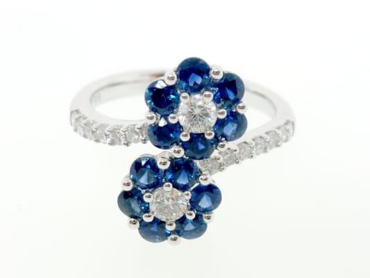 Double flower ring set with blue sapphires and diamonds crafted in 18k white gold.