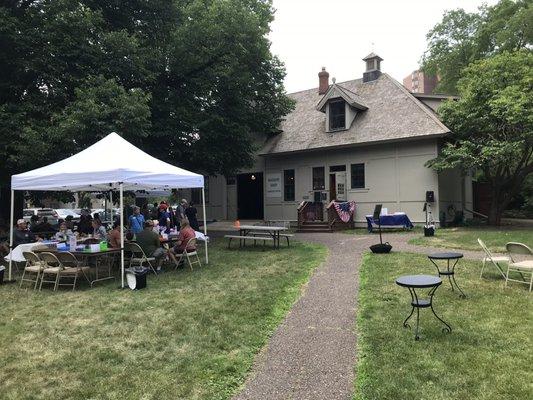 Outside on the lawn, looking at the carriage house and museum shop.