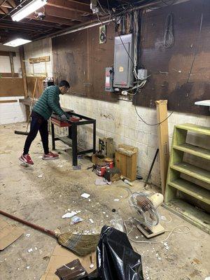 Crew member moving a few last items out of a basement that was filled to the brim with miscellaneous items