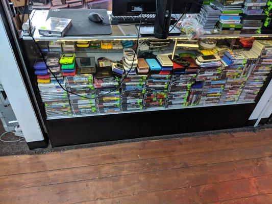 This showcase holds most of our handhelds, and beneath it is our collection of PSP games!